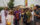Eight people smile and pose for a photo together while attending the ODUNDE Festival in Philadelphia. Four wear straw hats and most wear colorful patterned clothing.