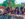 People stand against a fence barrier while singing, smiling and taking photos at The Roots Picnic in Philadelphia.