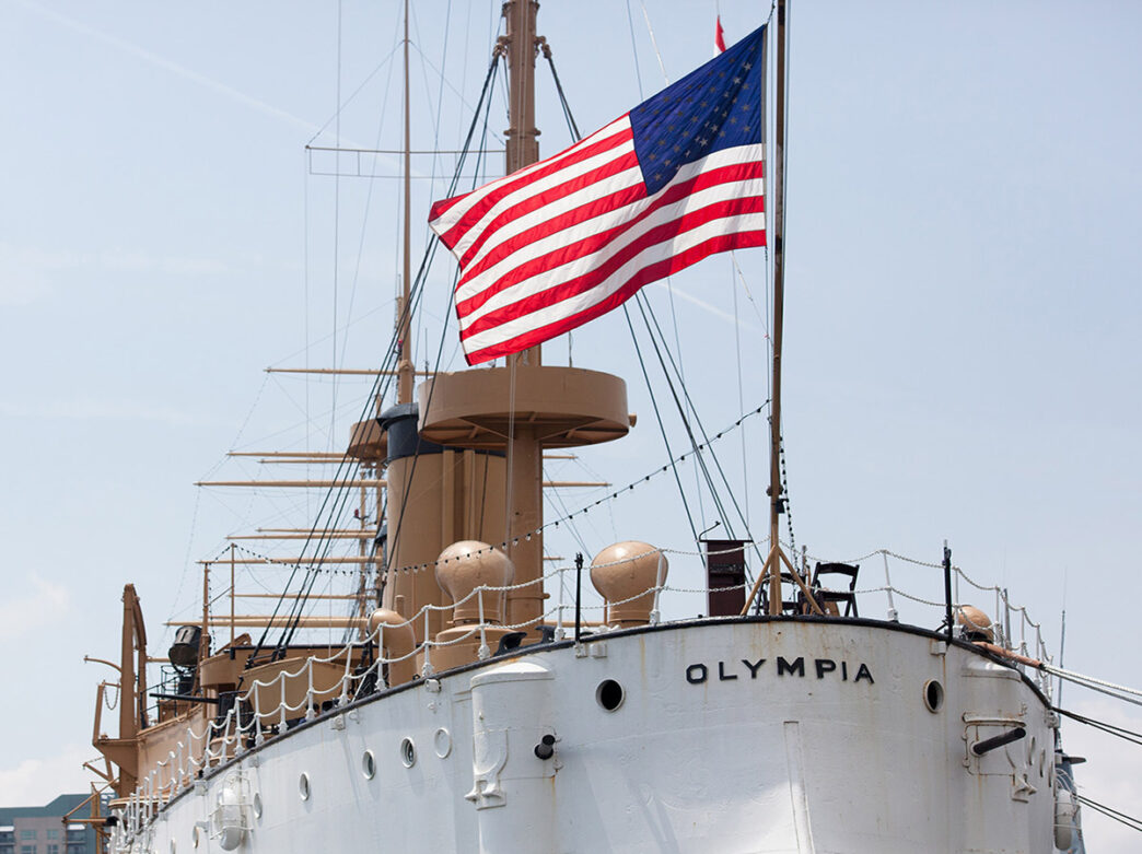 American flag waving above the Cruiser Olympia