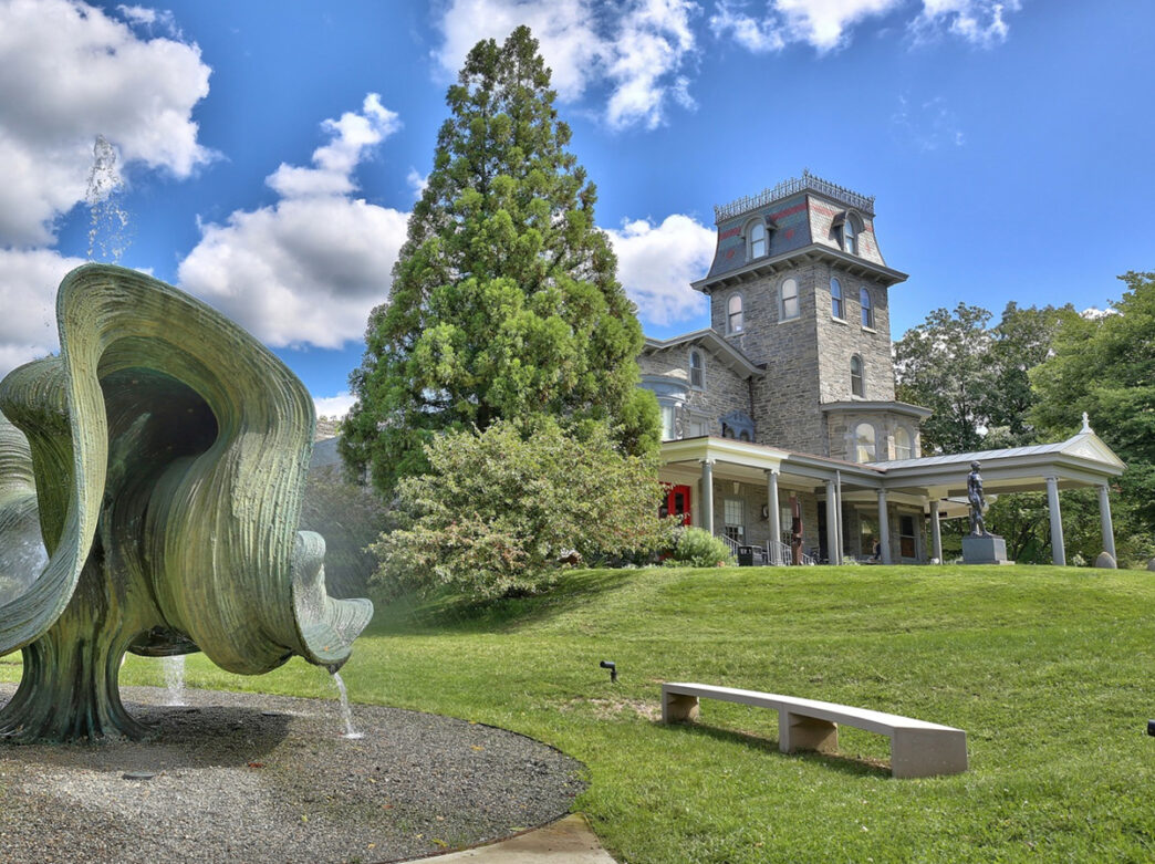Exterior of Woodmere Art Museum with an outdoor sculpture garden and trees surrounding the museum building.
