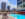 An outdoor rooftop pool with lounge chairs and daybeds with a view of the surrounding buildings.