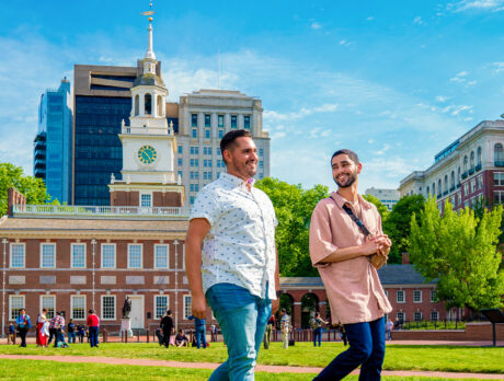 Two men walk through Independence Mall with Independence Hall in the background.