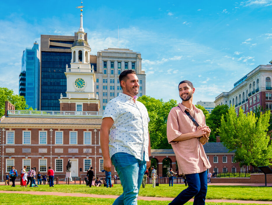 Two men walk through Independence Mall with Independence Hall in the background.