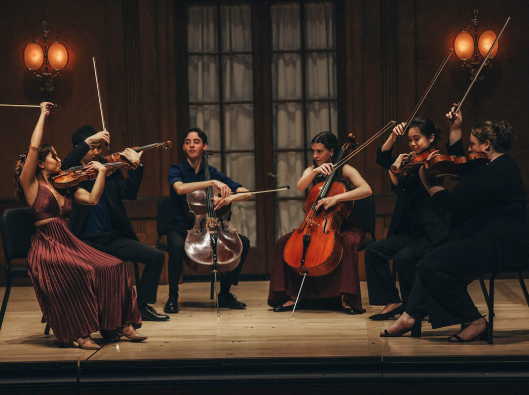 Classical musicians perform on stage.