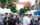People walk through the crowd and a street lined with vender tents during the Manayunk Arts Festival. An orange banner with Manayunk in white lettering hangs above the street.