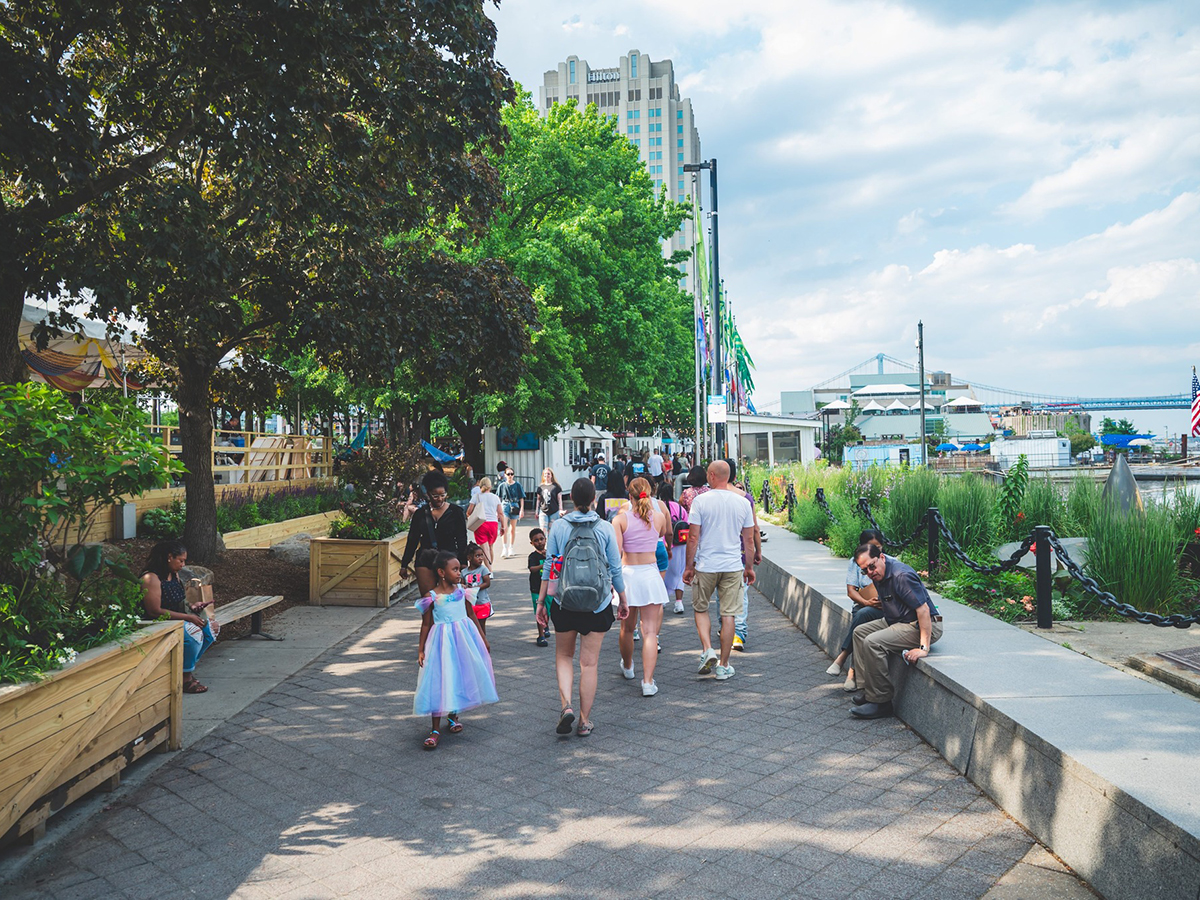 People walk on the walkway at Spruce Street Harbor Park.