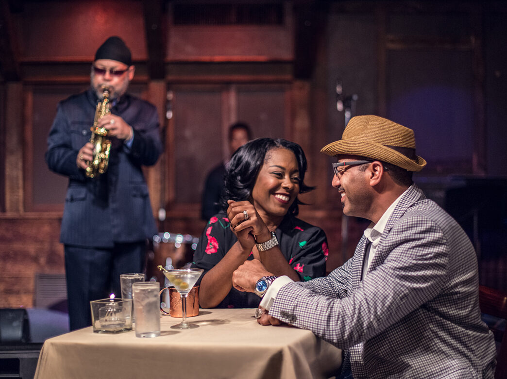 Um casal senta-se com coquetéis e ouve um saxofonista no Chris' Jazz Cafe, na Filadélfia.