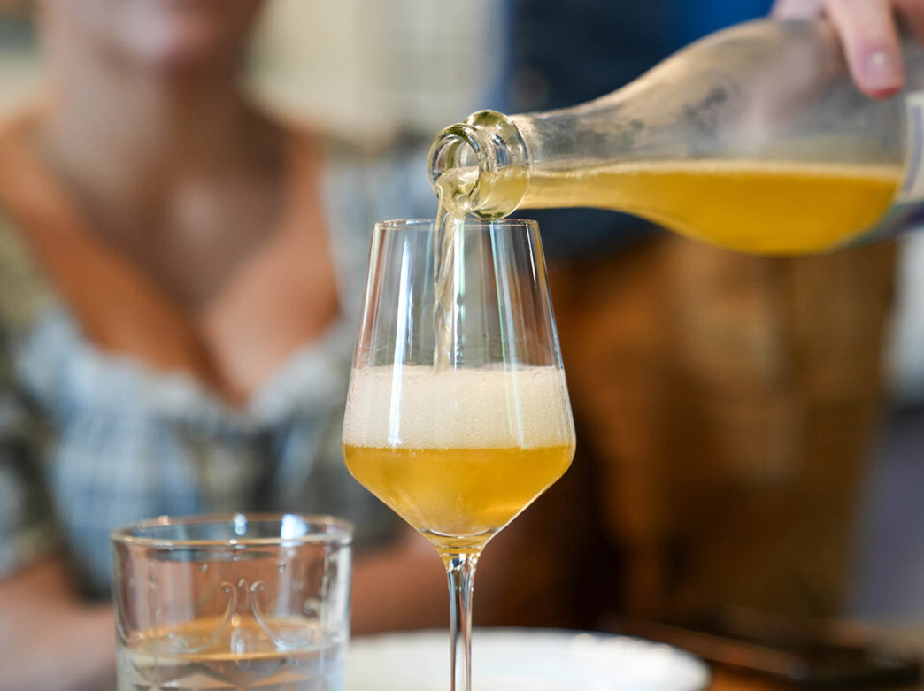 Vino de color ámbar vertido en una copa de vino en Mural City Cellars.