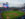 A view of a baseball field, people in the stadium and the Philadelphia city skyline in the distance.