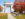 A couple sits on a bench in front of a large marble archway during the fall at Valley Forge National Park.