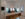Two people sit facing each other at am orange breakfast table in a hotel room at Yowie. A full length mirror hangs on one wall and a TV hangs on another.