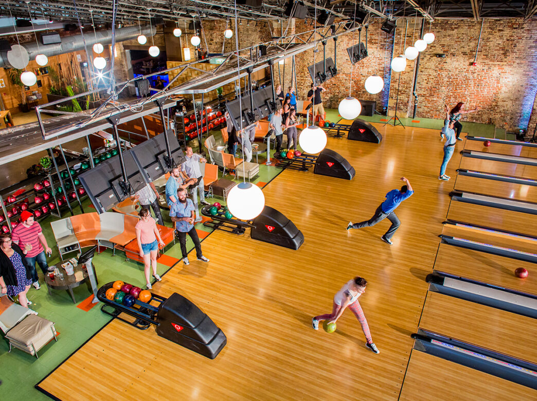 People bowling and sitting behind the bowling lanes at North Bowl in Philadelphia.