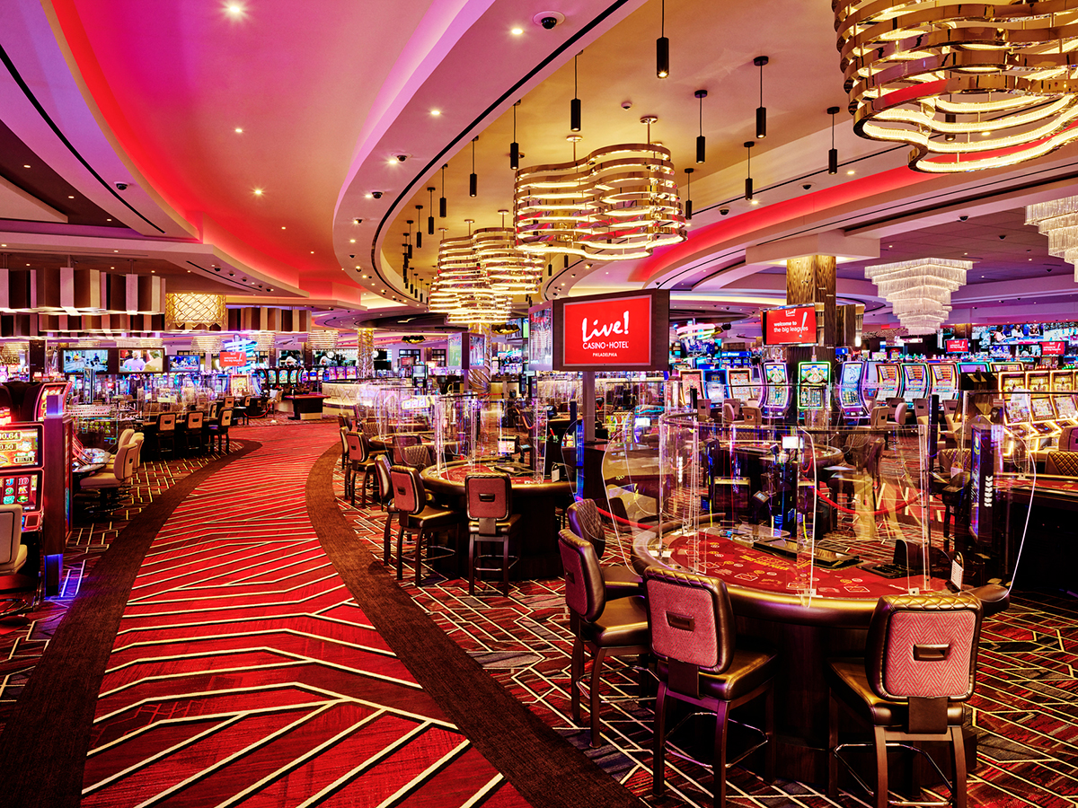 A casino floor with red carpet, game tables and slot machines at LIVE! Casino & Hotel in Philadelphia.