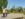 People walk along the pathways through Drexel Park with the Philadelphia skyline in the background.