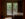 A dimly lit guestroom at the Black Bass Hotel looking outward to the Delaware River through French doors.