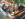 Two people lay head-to-toe in a colorful rainbow hammock at Spruce Street Harbor Park during the day.