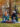 Two women sit in the grass together drinking coffee and laughing in Rittenhouse Square on a fall day.
