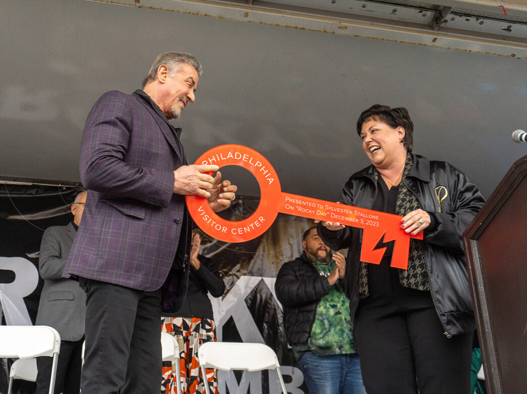 Sylvester Stallone stands on stage and accepts a large red key in celebration of Rocky Day.