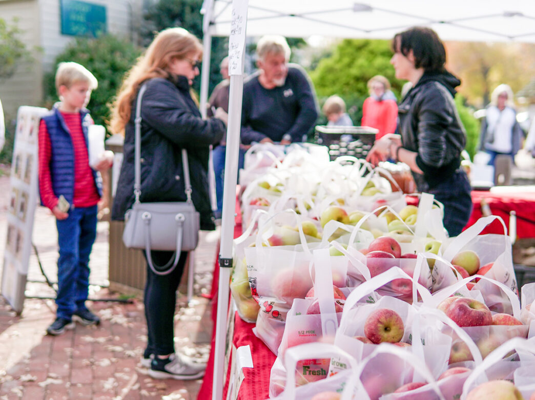 People buy apples by the 1/2 peck from a vendor during the Apple Festival at Peddler's Village.