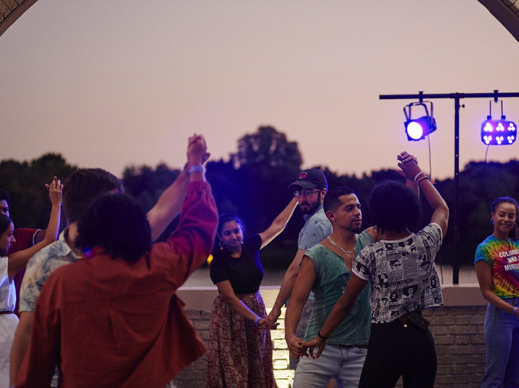 People salsa dance in pairs at FDR Park Boathouse for Bailar en FDR.