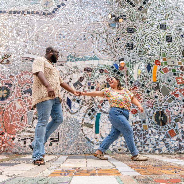 One person leads another through the mosaics at Philadelphia's Magic Gardens.