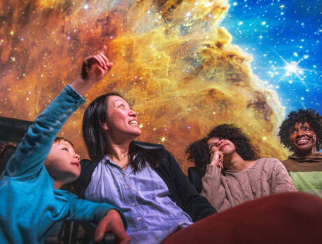 Four people looking up into space at The Franklin Institute's planetarium