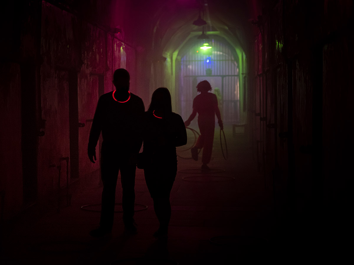 Visitors are followed down a dark hallway by a scary haunted house character.