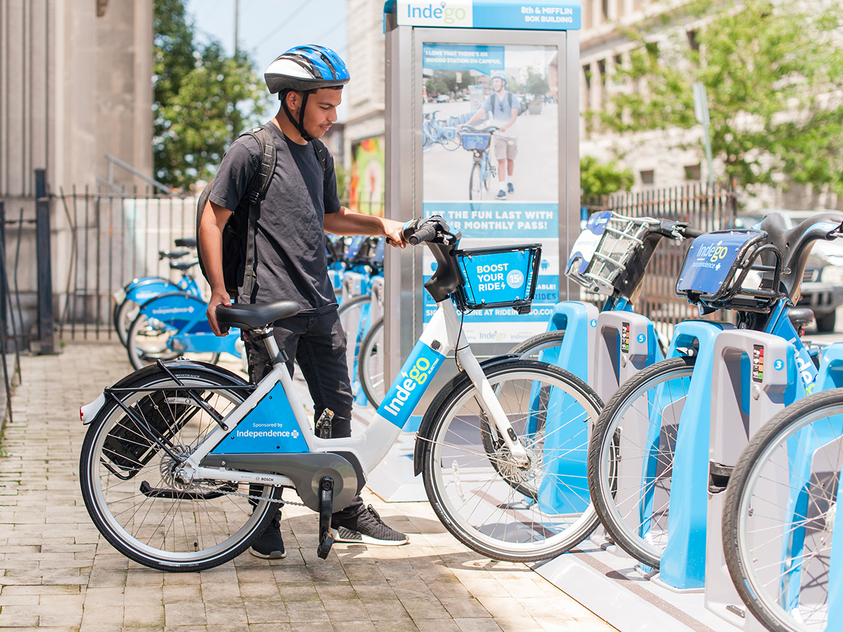 A person takes a bike from the Indego docking station at 8th and Mifflin outside the Bok Building.