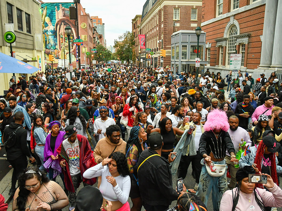 Una multitud enorme de asistentes al festival OURfest camina por la calle.