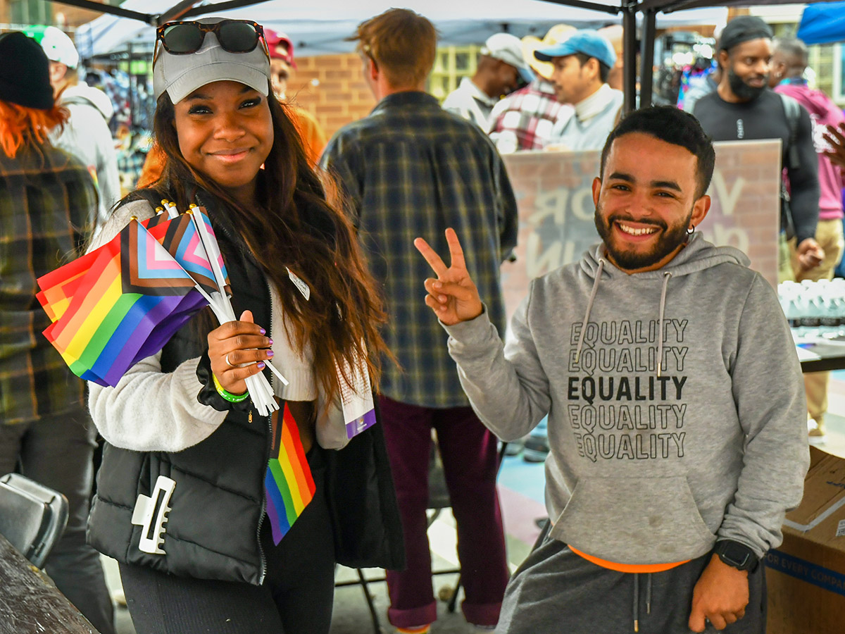 Dos asistentes al festival OURfest bien vestidos sonríen.