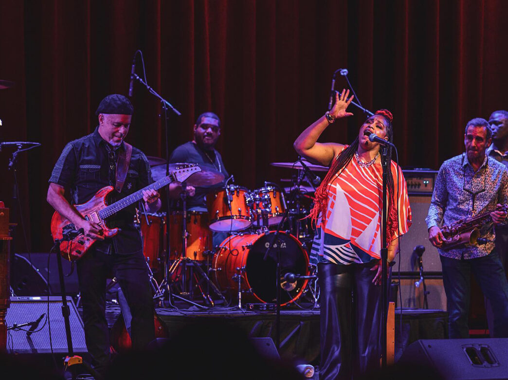 A jazz band, including an electric guitarist, drums player, saxophonist and singer, perform on stage during the Montco Jazz Fest.