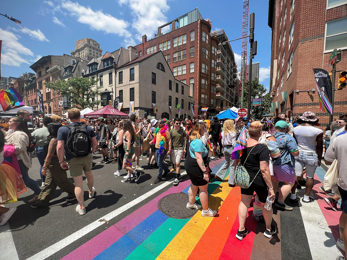 Una multitud se reúne en lo alto de un cruce peatonal de arcoíris en Filadelfia durante OURFest
