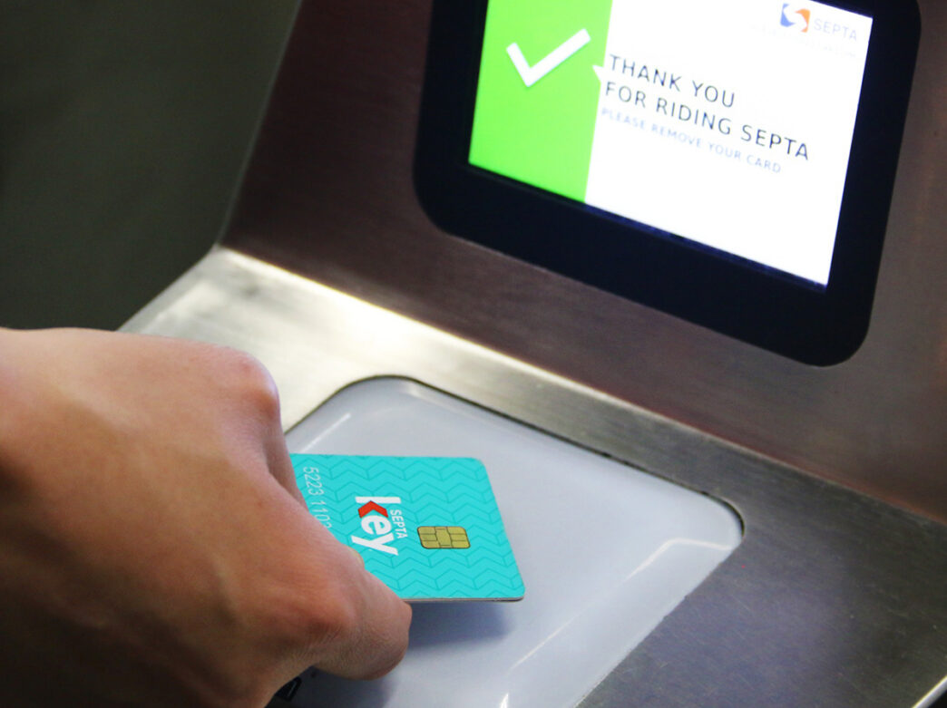 Une personne tape sa carte-clé SEPTA à un kiosque pour payer son trajet.