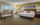 A modern hotel room featuring a king-size bed with crisp white linens, a seating area with a plush couch and coffee table, and floor-to-ceiling windows showcasing scenic views.
