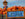A massive, smiling scarecrow stands behind a ton of bright orange pumpkins and a blue sign that says "Linvilla Orchards."