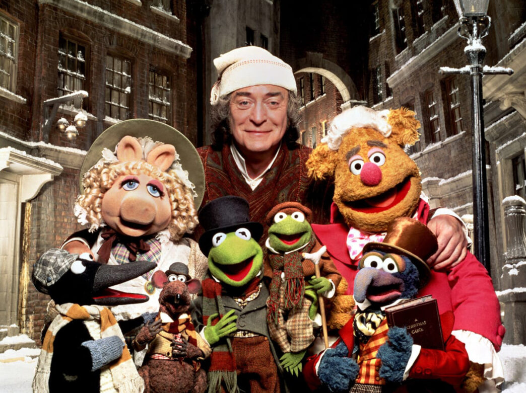 Muppet characters pose for a photo in front of a snowy backdrop for Muppet Christmas.