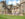 Two people sit on a bench on a clear blue day with the Fonthill Castle in the background.