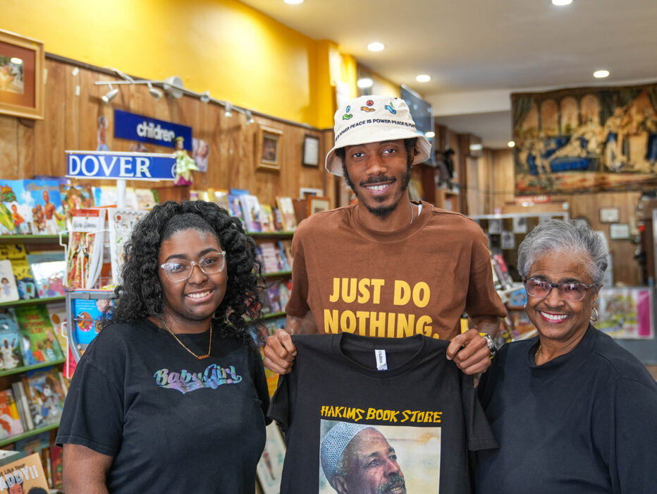 Três pessoas se postam para uma foto e sorriem para a câmera na Hakim's Bookstore, na Filadélfia