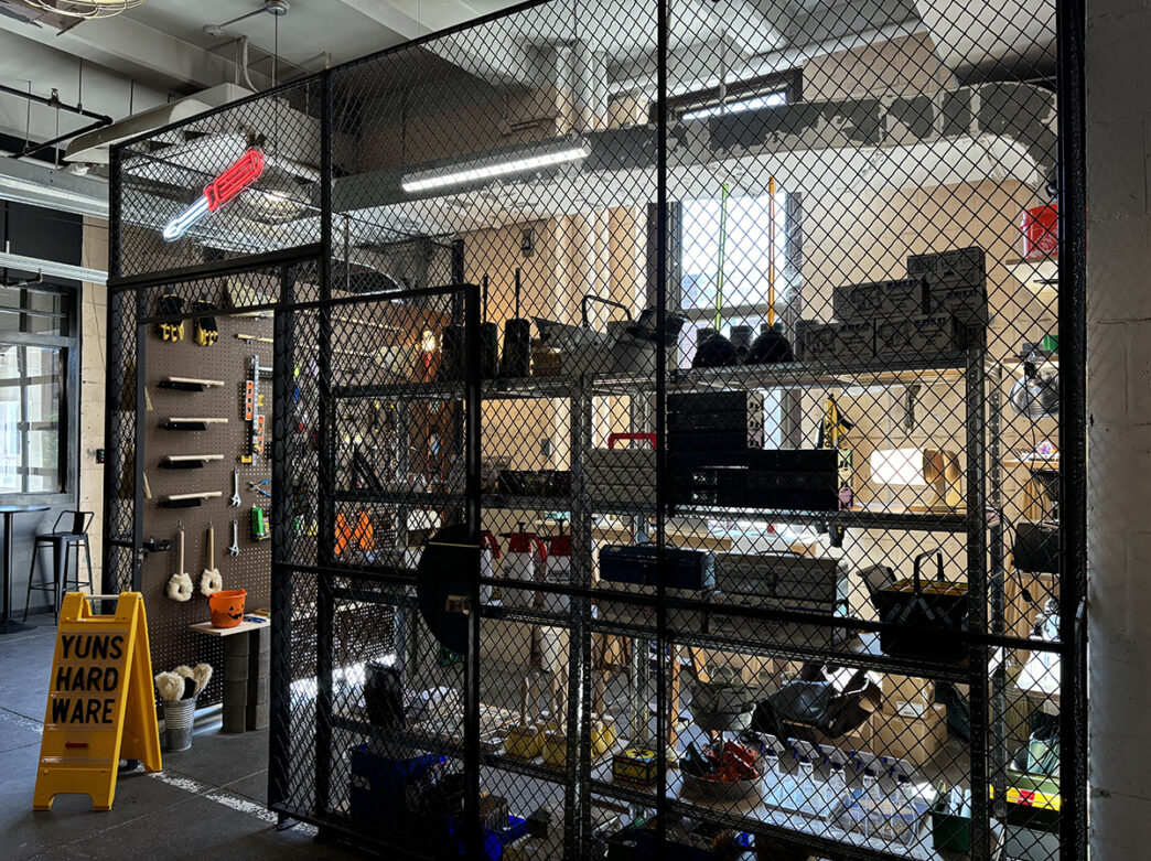 Tools and hardware items are displayed in a store front on shelves and pegboard at Yuns Hardware.