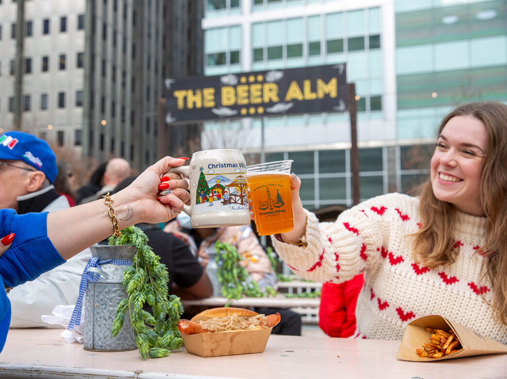 Two people toast during Christmas Village in Philadelphia at LOVE Park