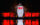 A towering illuminated penguin with a glowing red bow tie stands against a vivid red backdrop at the LumiNature display at the Philadelphia Zoo.