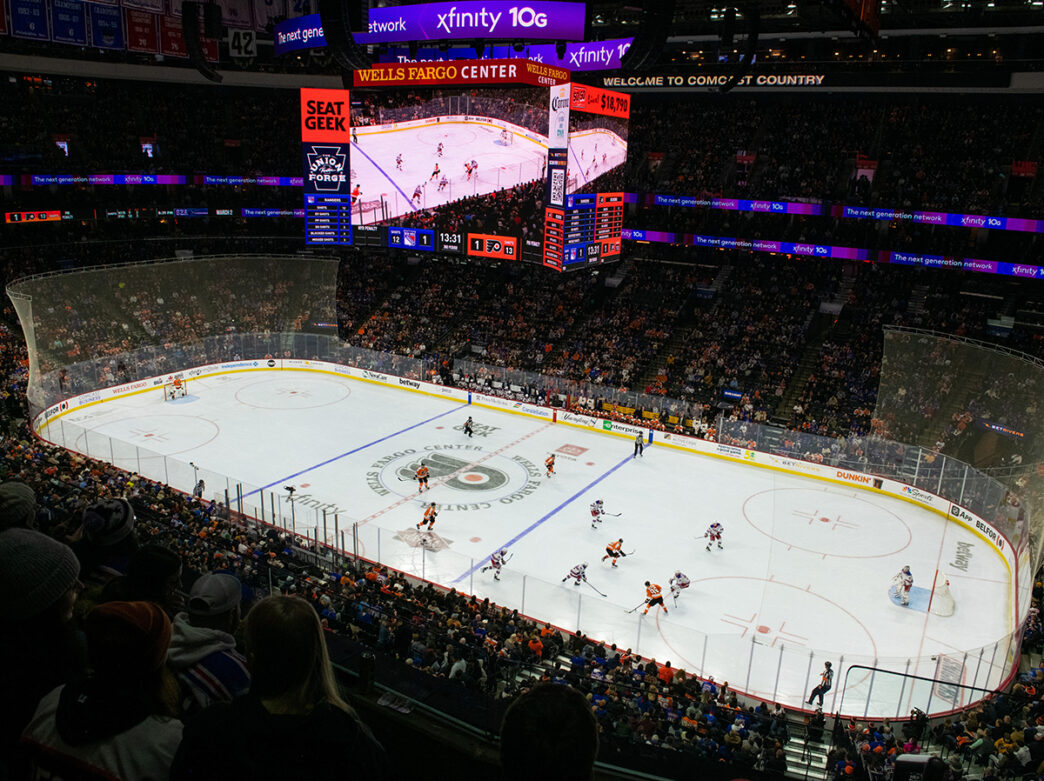 The Philadelphia Flyers play a hockey game on the ice rink at the Wells Fargo Center. Fans sit in the stands.