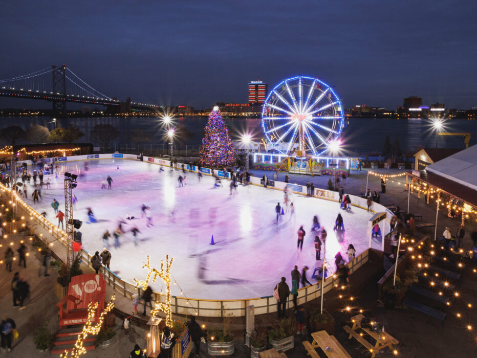 A bird's-eye view of the ice skating rink, colorful holiday tree and illuminated Ferris wheel at Independence Blue Cross RiveRink Waterfront.
