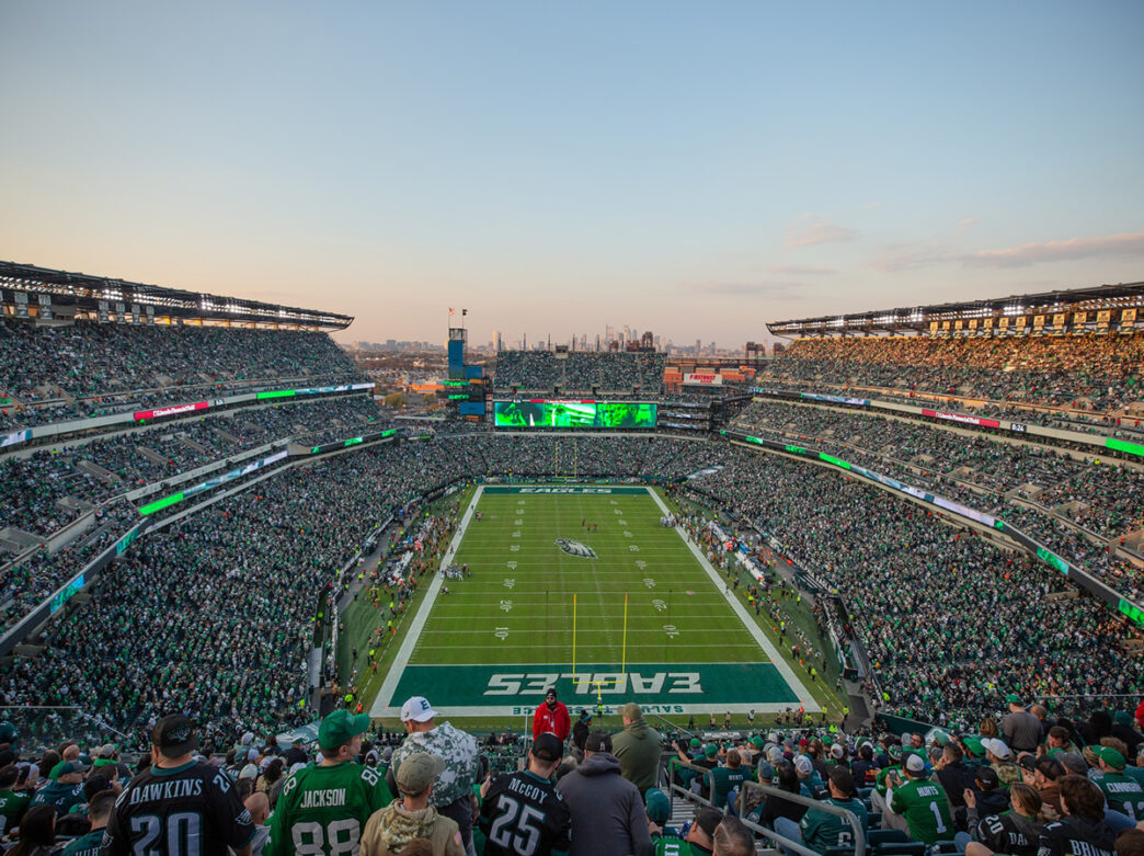 Philadelphia Eagles fans fill Lincoln Financial Field to watch the Eagles play. The Philadelphia skyline can be seen in the distance.