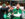 Three Philadelphia Eagles fans hug each other and celebrate while watching a game. One fan's face is painted white and green and the other two wear green Eagles attire.