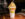 A light pink milkshake in a tall cup topped with whipped cream and colorful Fruity Pebbles.
