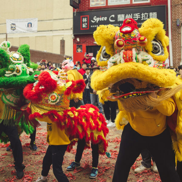 People gather to watch a performance of a traditional lion dance during the Lunar New Year Parade in Chinatown.