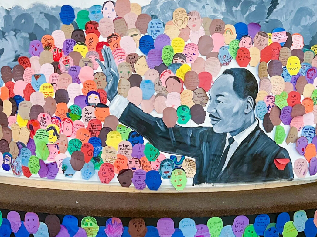 A mural of Martin Luther King Jr. at the Please Touch Museum is decorated with colorful cutout drawings.