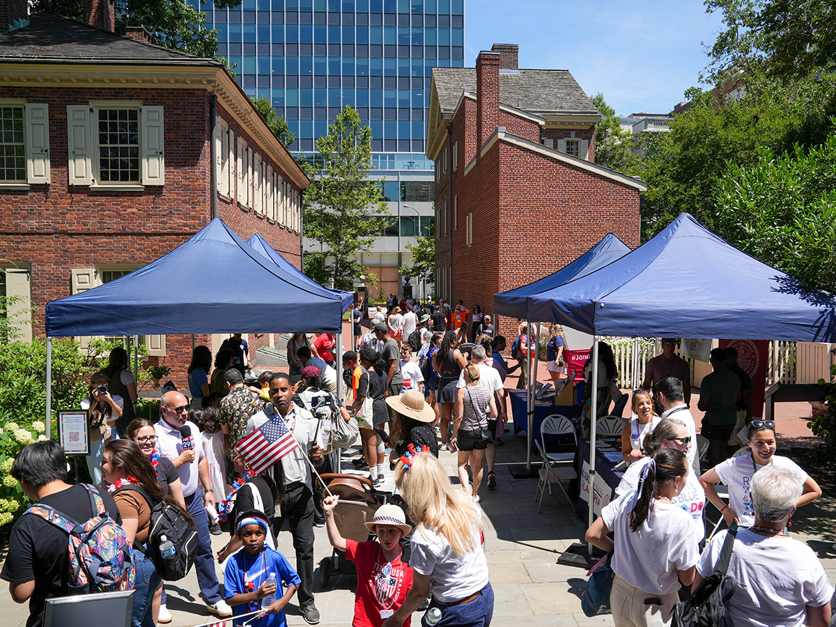 People gather around and under tends outdoors during the Red White & Blue To Do.