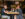 A couple sit across from each other while sitting at a table in Booker’s Restaurant & Bar. There are champagne glasses and a small bouquet of flowers on the table.